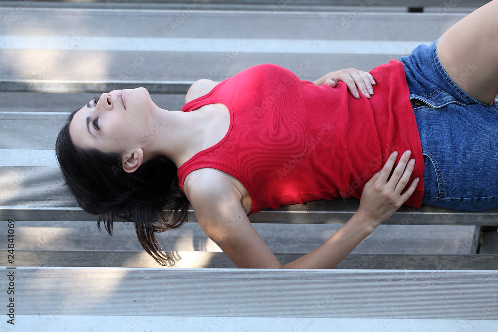 Fototapeta premium young latina teen girl reclining on bleachers