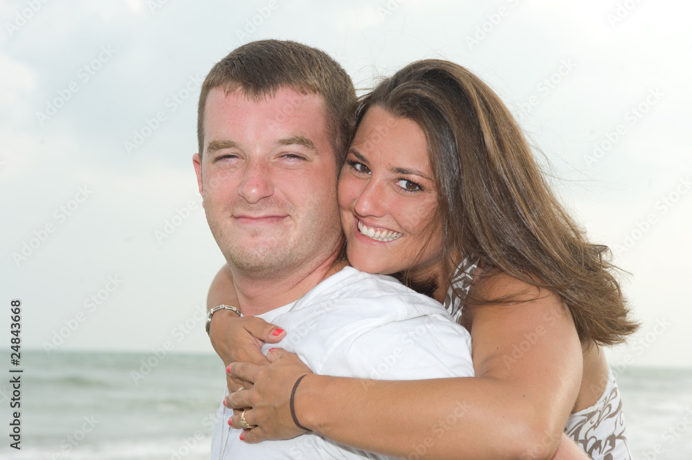 Happy young couple smiling at the beach Happy young couple smiling at the beach