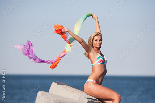 Beautiful young lady with colorful scarf on the beach