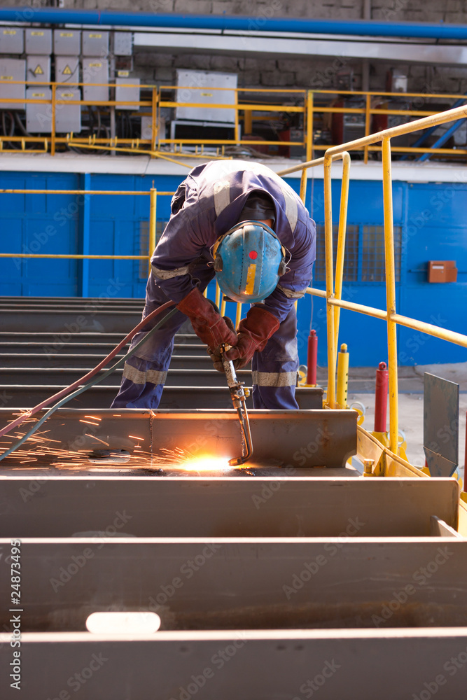 Naklejka premium worker weld metal in factory and sparks