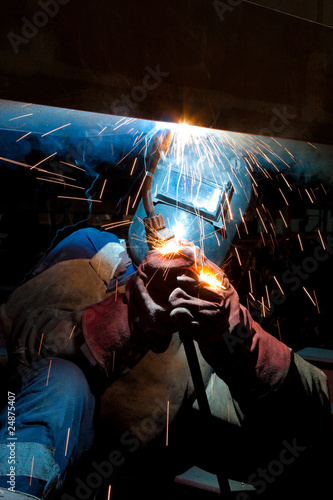 worker weld metal in factory and sparks