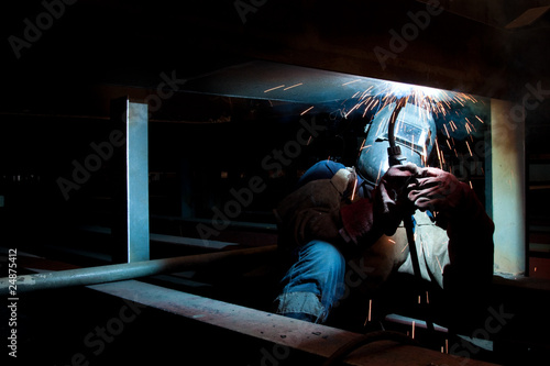 worker weld metal in factory and sparks