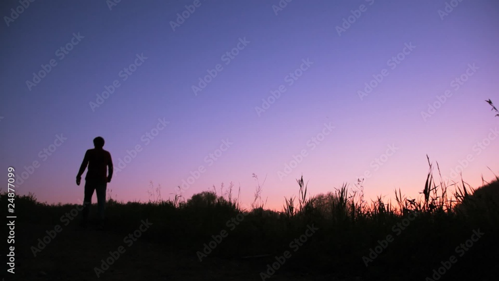 silhouette of man walks uphill against sky silhouette of man walks uphill against sky