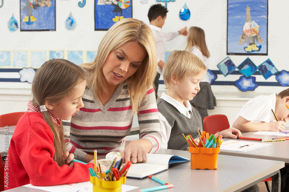 Naklejka premium Group Of Primary Schoolchildren And Teacher Having lesson In Cla