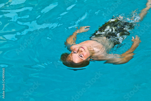 boy enjoys swimming in an outdoor pool photo