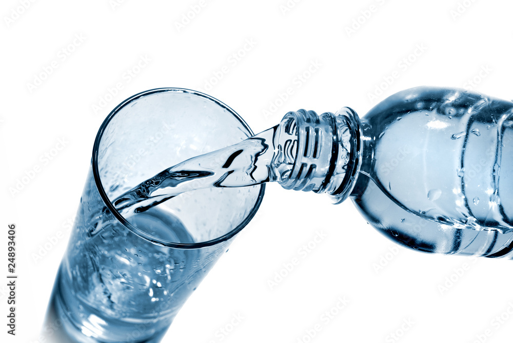 water pouring into glass from bottle isolated on white water pouring into glass from bottle isolated on white