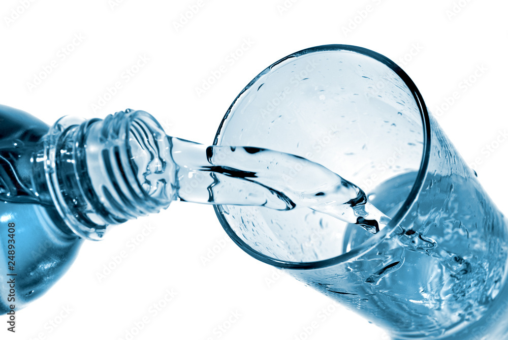 water pouring into glass from bottle isolated on white water pouring into glass from bottle isolated on white