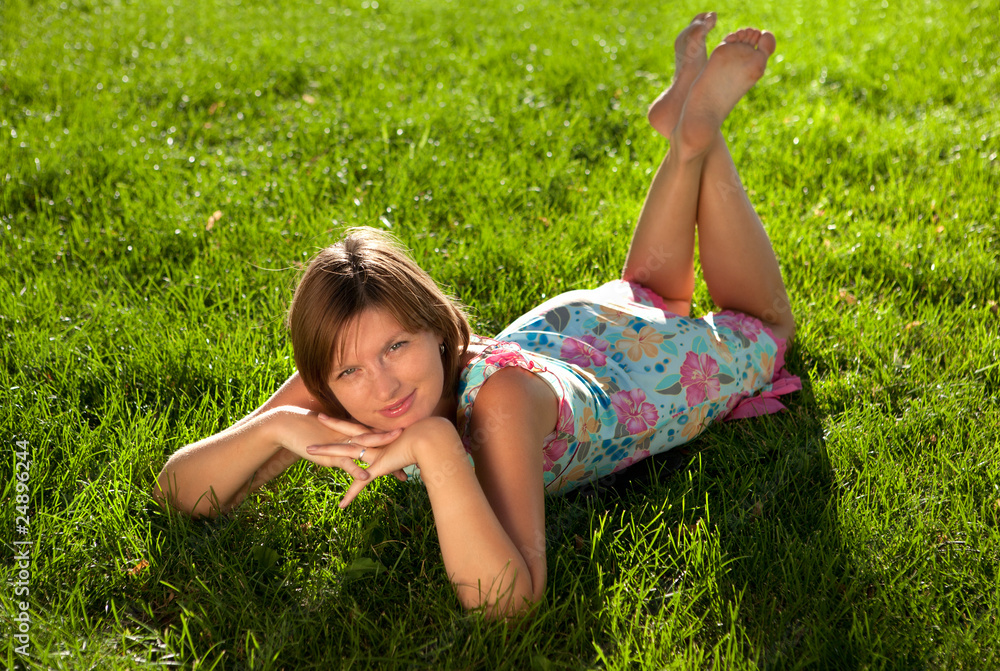 The beautiful girl having a rest on a grass in summer day The beautiful girl having a rest on a grass in summer day
