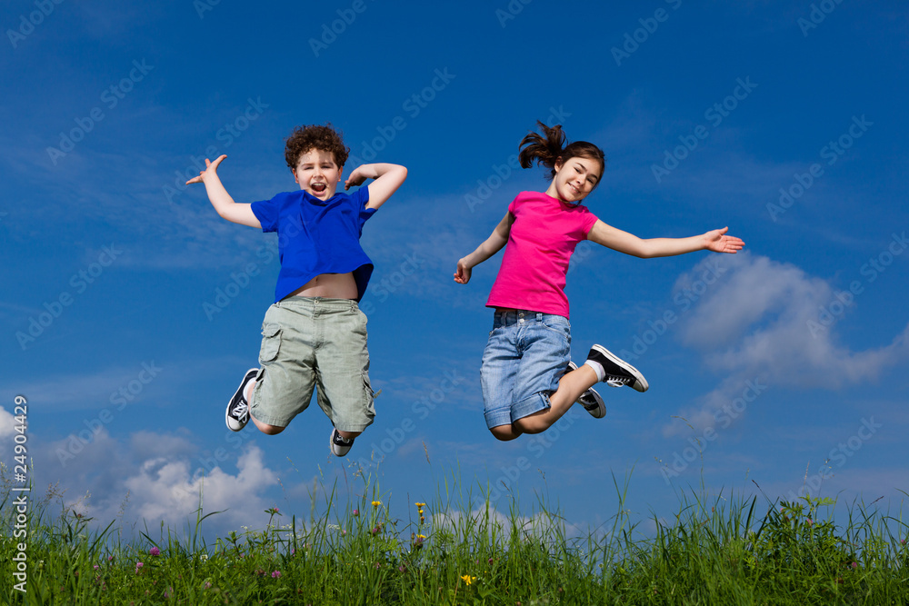 Girl and boy jumping, running against blue sky Girl and boy jumping, running against blue sky