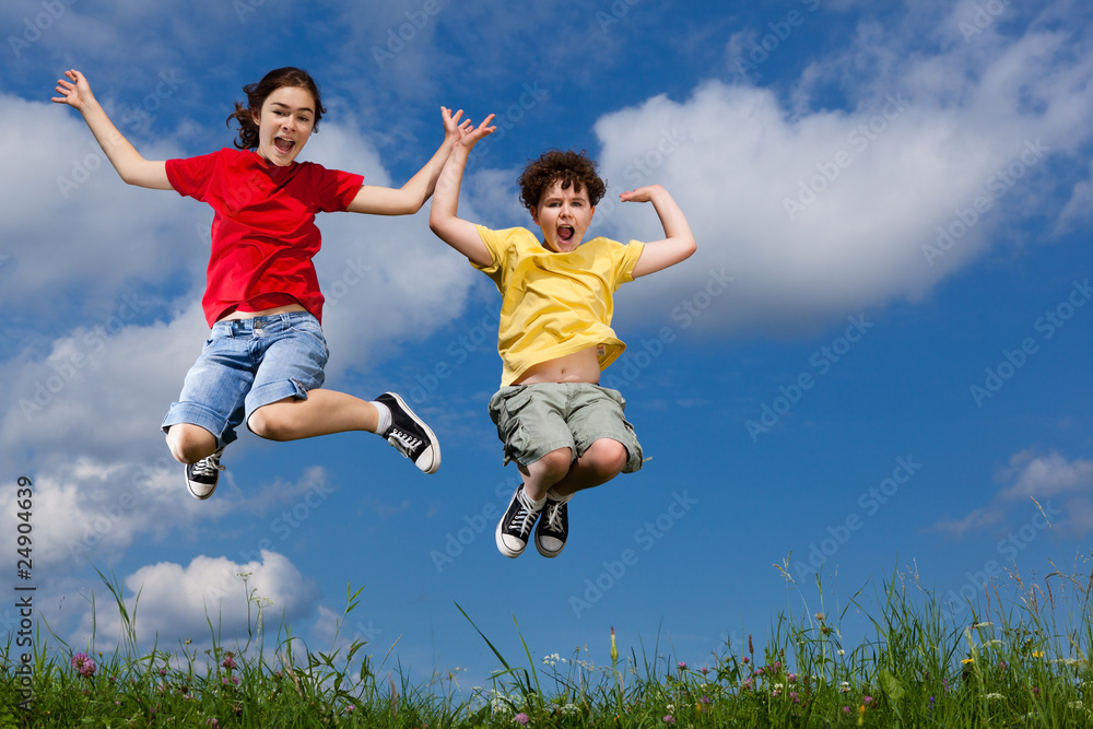 Girl and boy jumping, running against blue sky Girl and boy jumping, running against blue sky