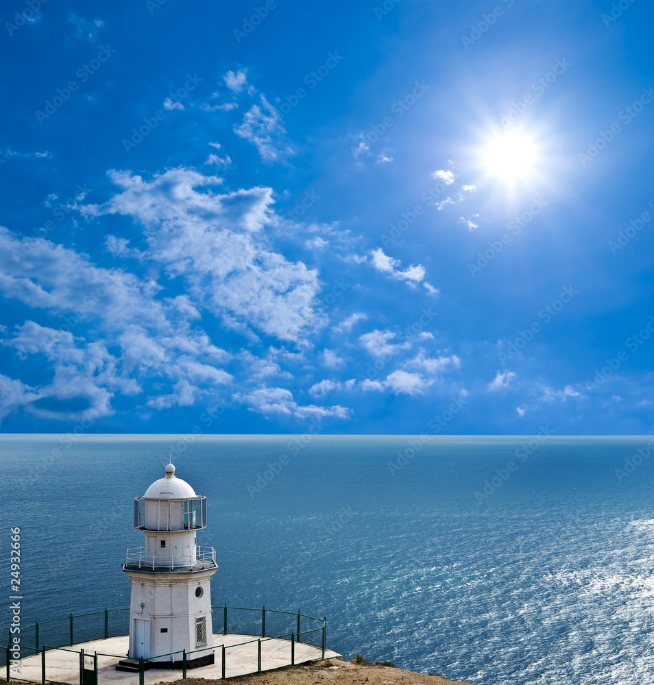 lighthouse on a marine cape under sparkle sun