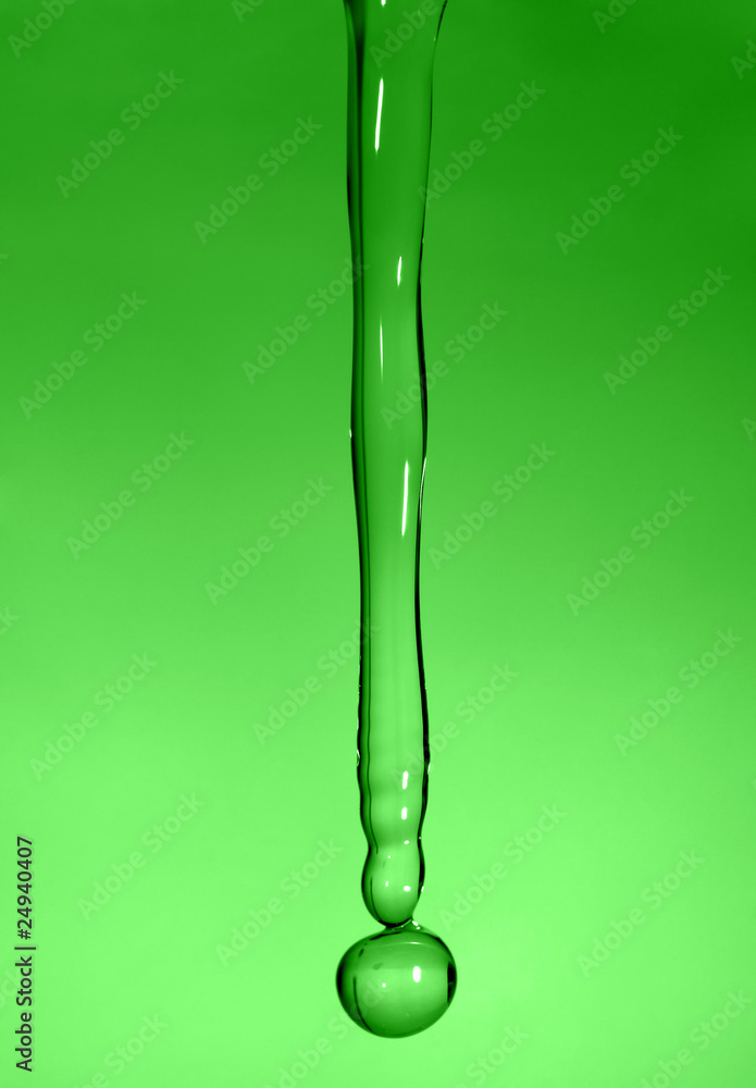 falling transparent drop of water in a green background falling transparent drop of water in a green background