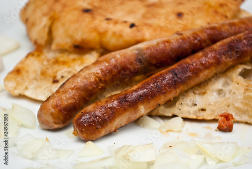 two beed sausages on flatbread with onion