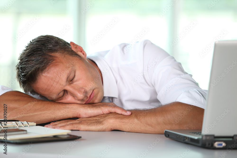 Fototapeta premium Businessman asleep on his desk