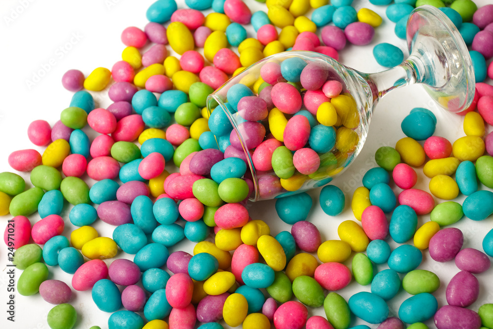 Obraz premium Color candie beans in glass on white background