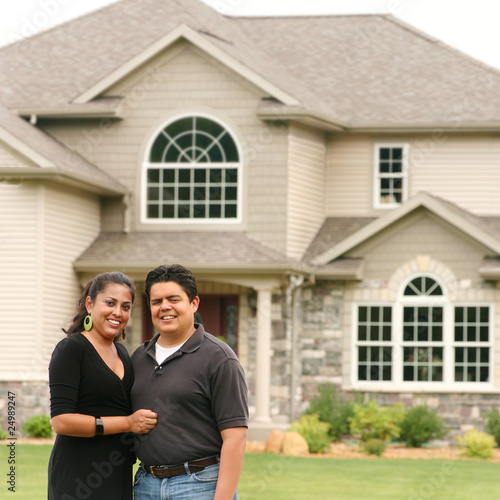 Картината върху платно Happy couple in front of a house portrait
