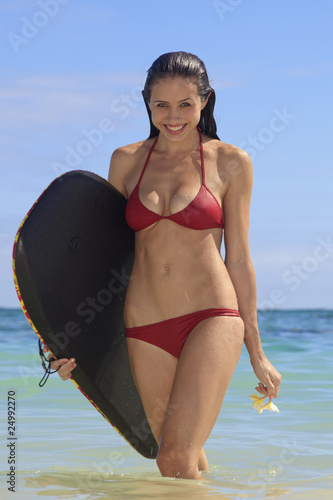Canvas Print young woman at the beach in hawaii with her boogie board