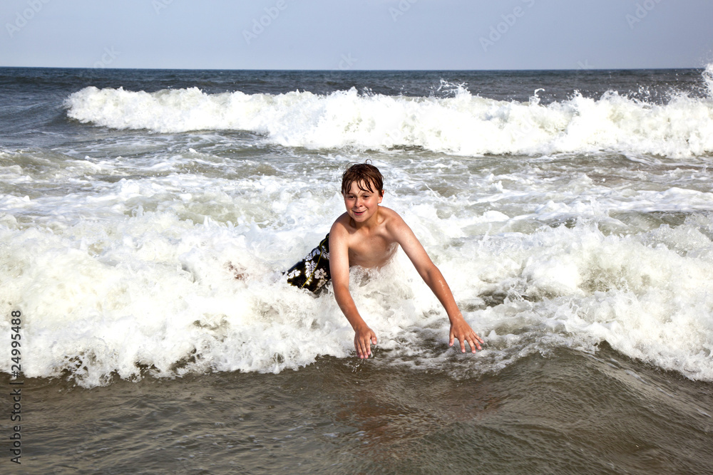 boy enjoys the waves of the ocean boy enjoys the waves of the ocean