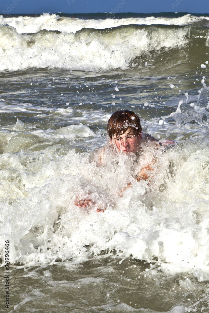 child has fun in the waves of the ocean