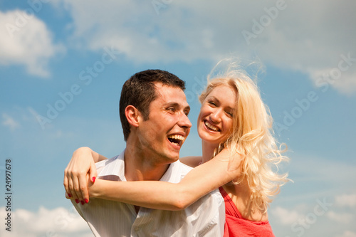 Young love Couple smiling under blue sky