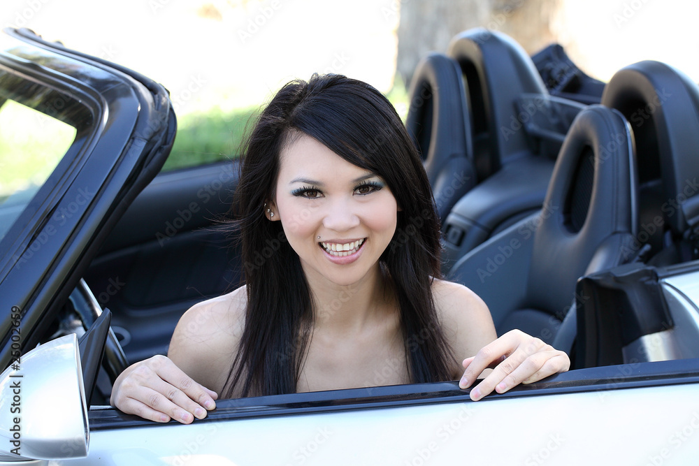 Young asian woman sitting in convertible car