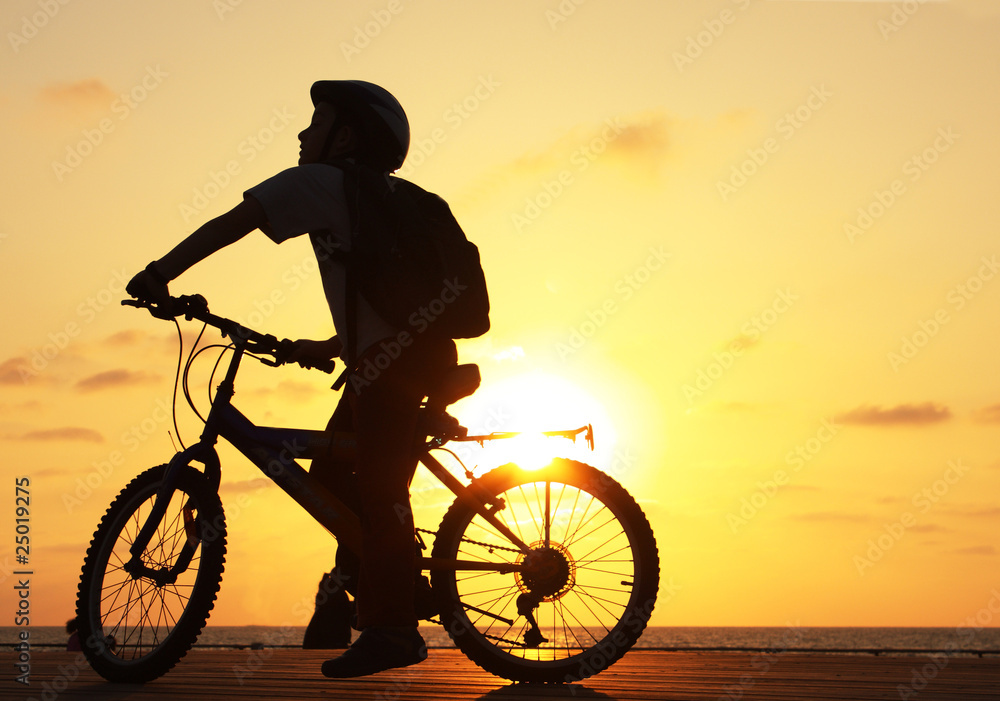 Fototapeta premium Silhouette of teenager riding bicycle