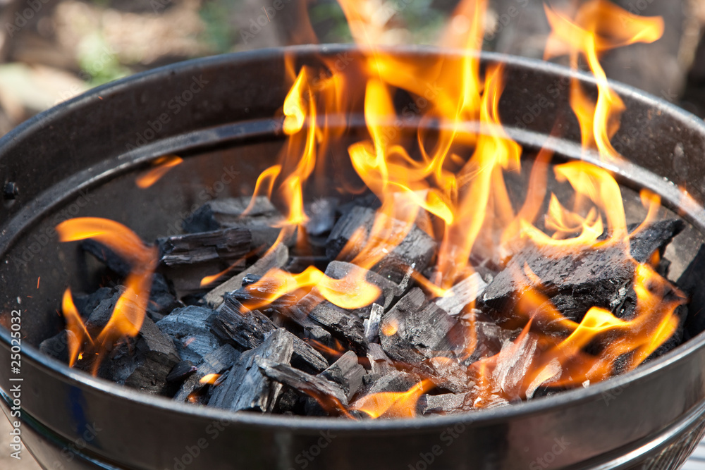 A grill with charcoal and flames A grill with charcoal and flames