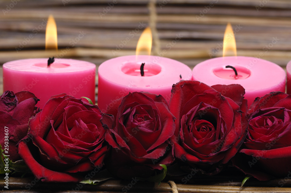 row of candles with red rose