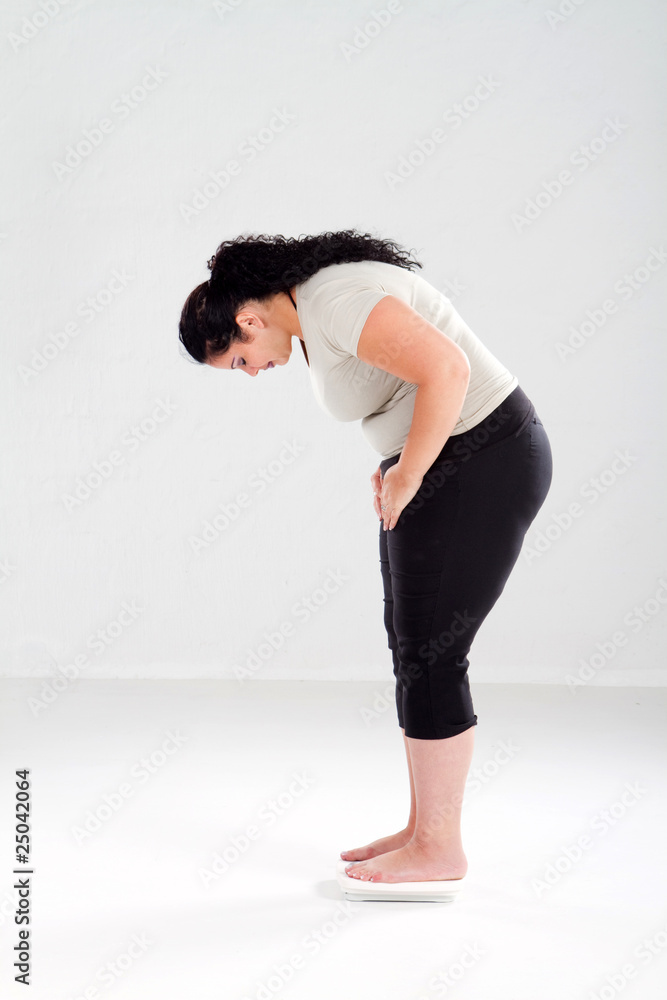 Woman standing on scales Stock Photo by ©belchonock 148838871