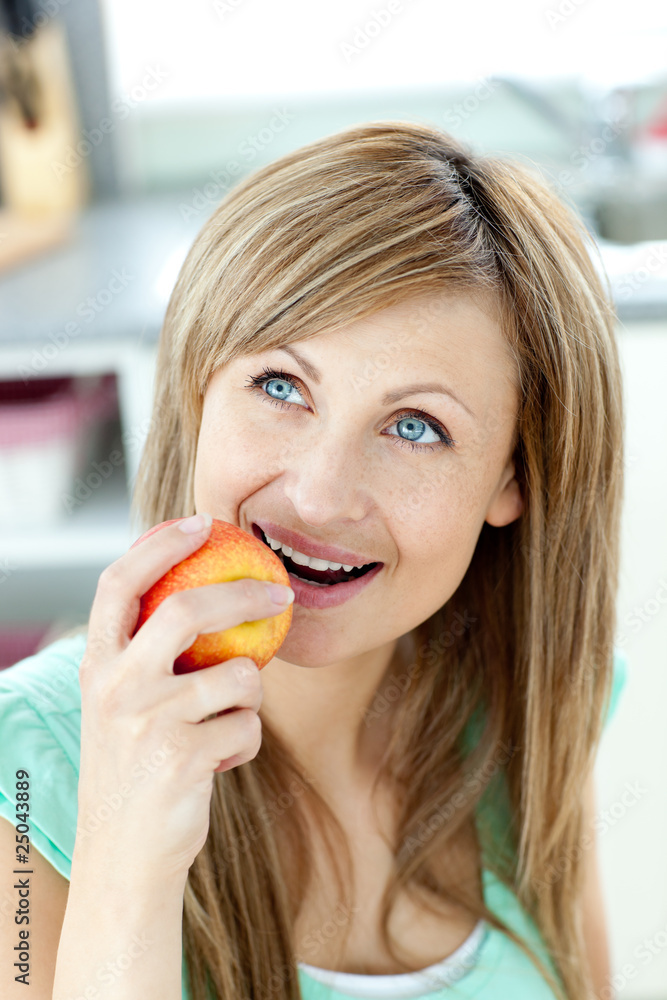 Captivating caucasian woman eating an apple in the kitchen Captivating caucasian woman eating an apple in the kitchen