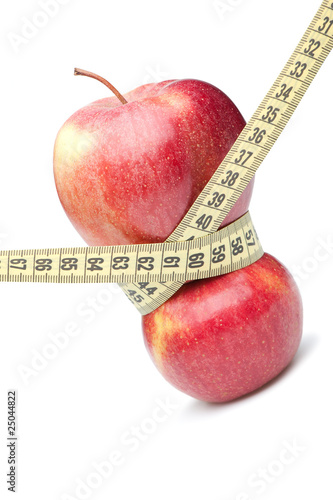 Closeup of a red apple with a measuring tape. Isolated on white