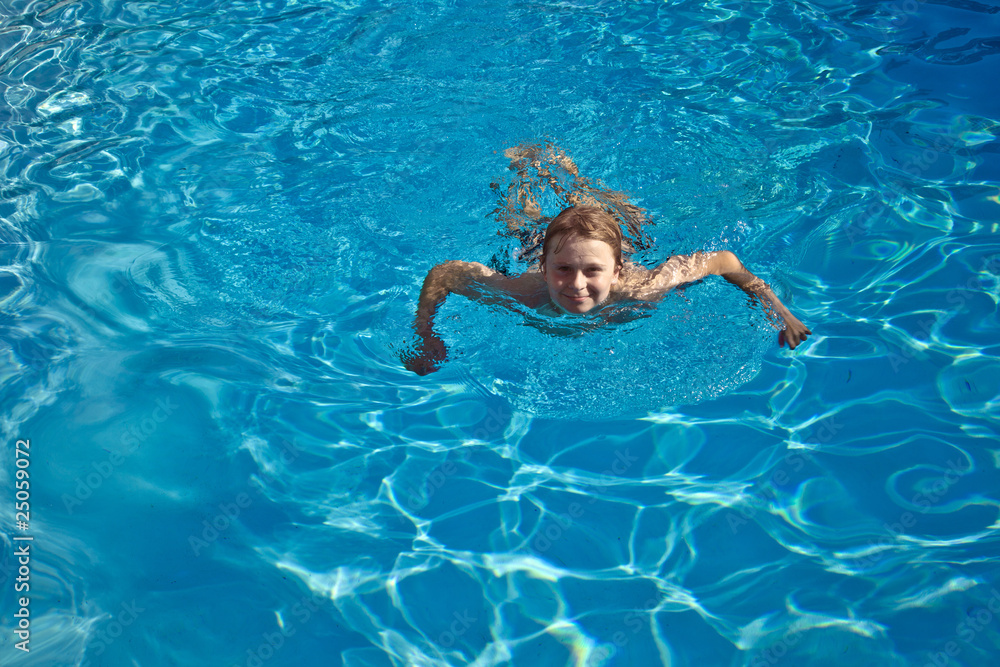 child swims in the pool and has fun