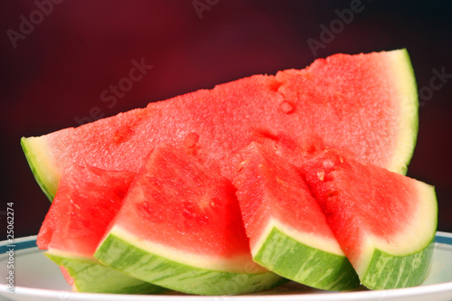 Watermelon slices set against a red background