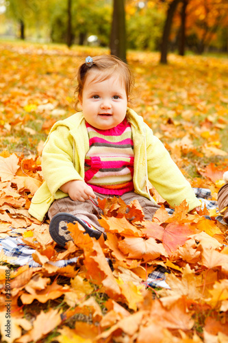 Toddler in golden leaves