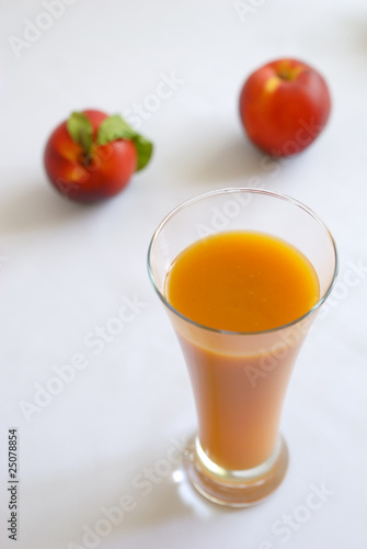 Glass of juice and two peaches