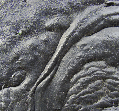 flow of a black reflective tar lava like substance