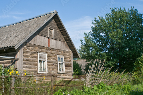 Деревянный деревенский дом за забором