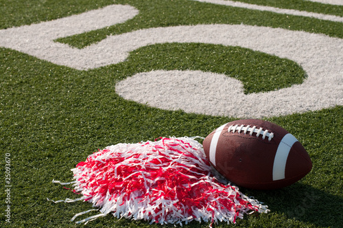 American Football and Pom Poms on Field photo