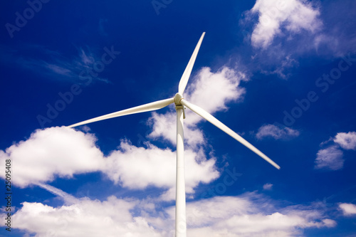 Windmill against a blue sky and clouds, alternative energy sourc photo