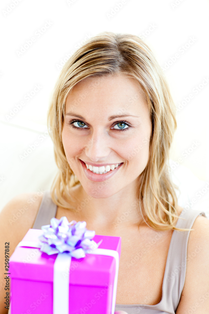 Smiling woman holding a present looking at the camera Smiling woman holding a present looking at the camera