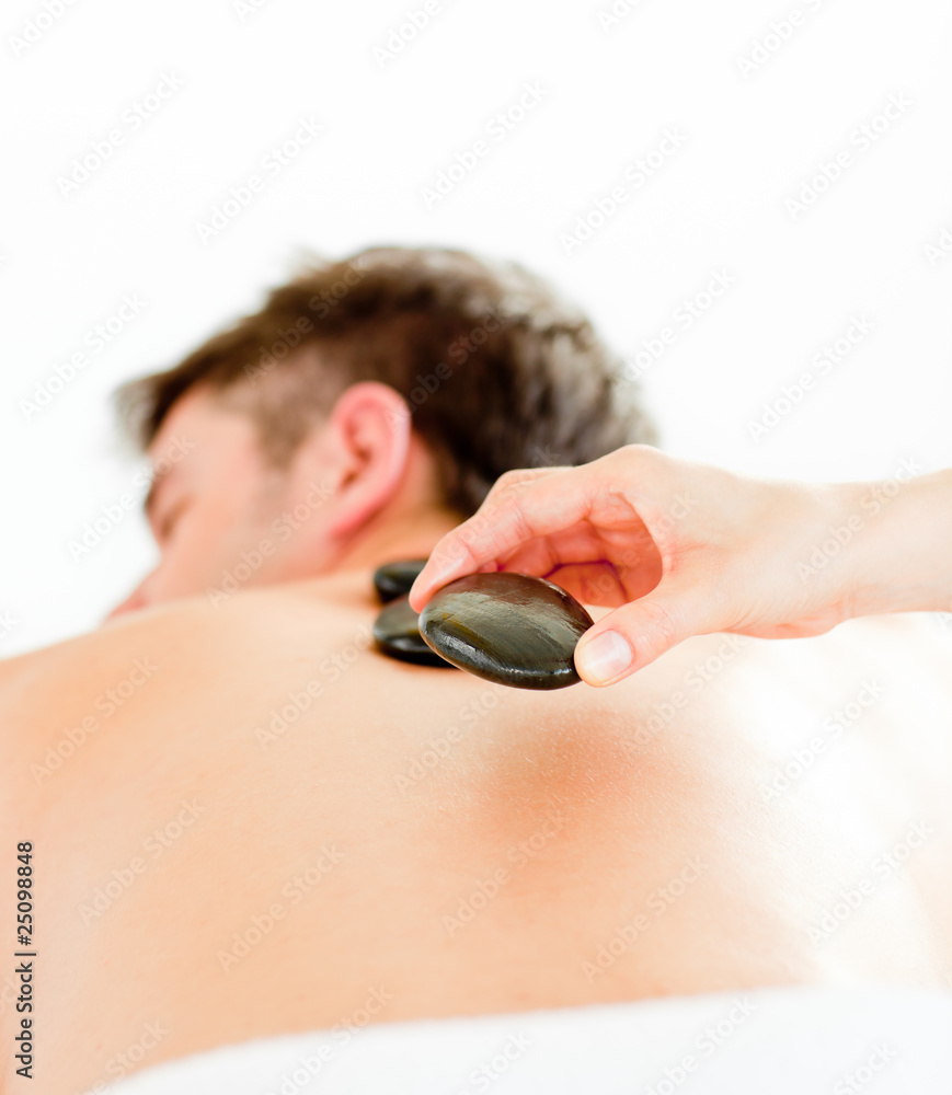Fototapeta premium Close-up of a positive young man having a back massage with hot