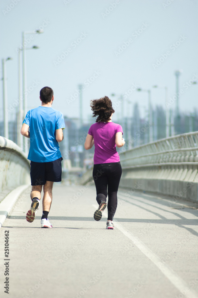 Young people jogging on bridge