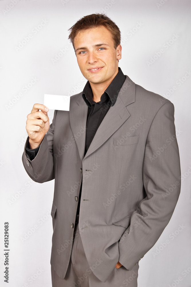 Attractive young man in light suit with business card Attractive young man in light suit with business card