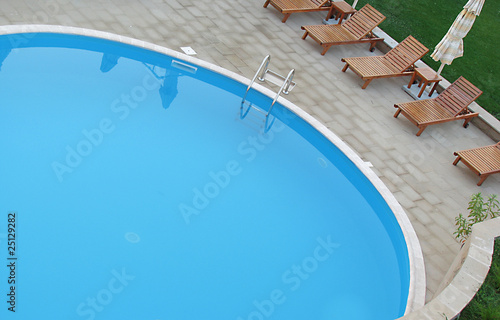 beautiful swimming pool surrounded by chairs © maya