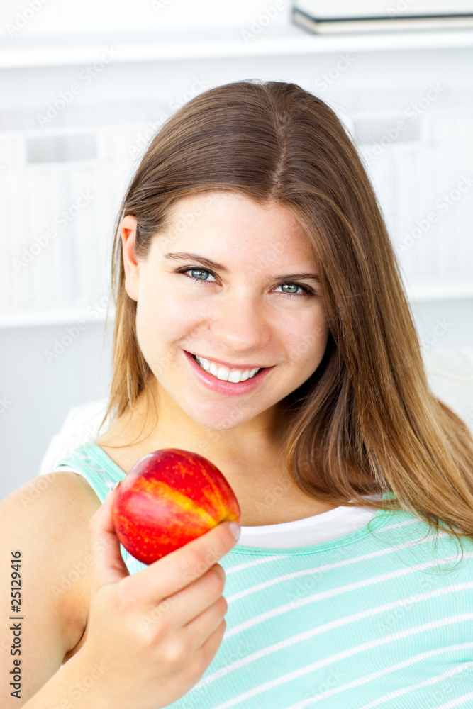 Pretty caucasian woman holding an apple at home Pretty caucasian woman holding an apple at home