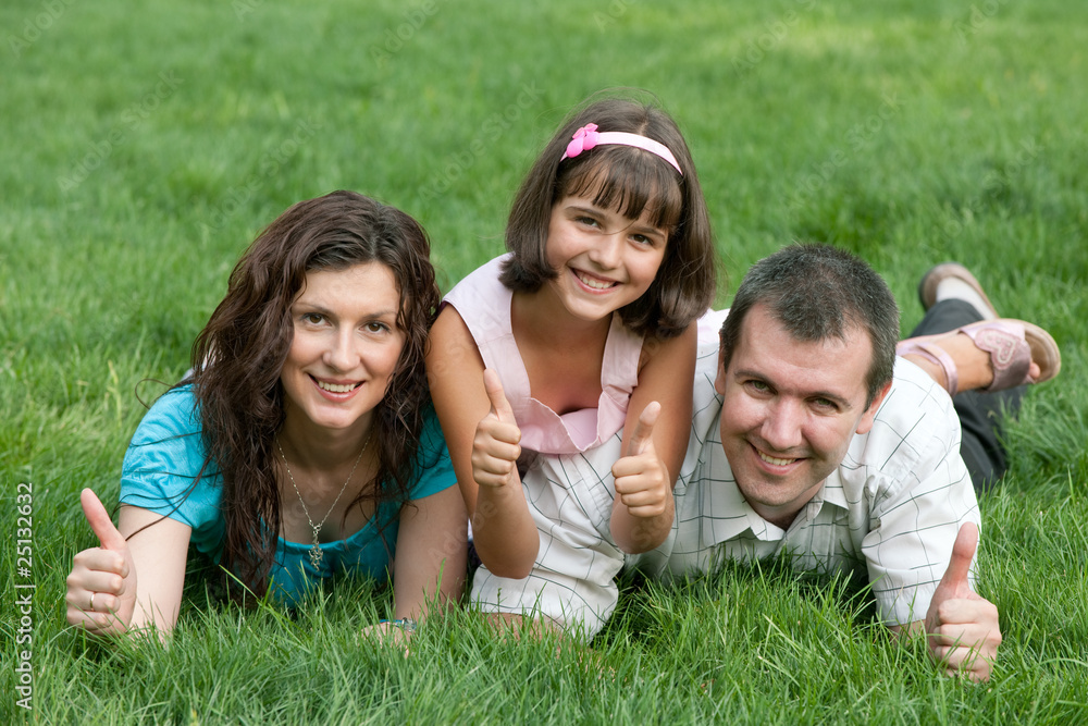 Family of three with thumbs up in the park Family of three with thumbs up in the park