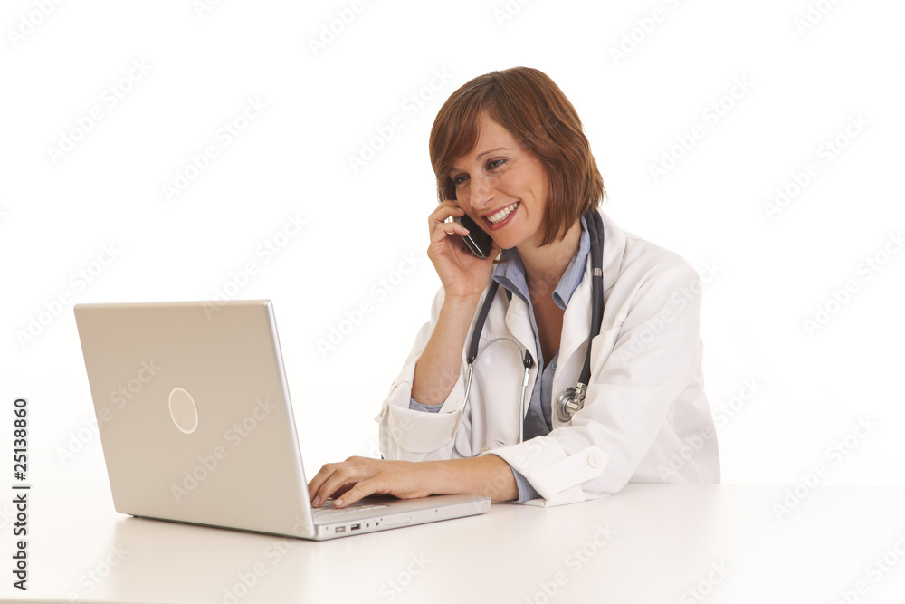 Portrait of young woman doctor at computer using phone Portrait of young woman doctor at computer using phone