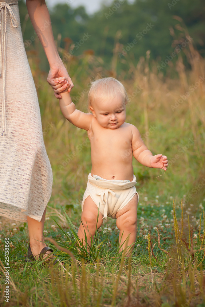 baby walking holding mother hand in park baby walking holding mother hand in park