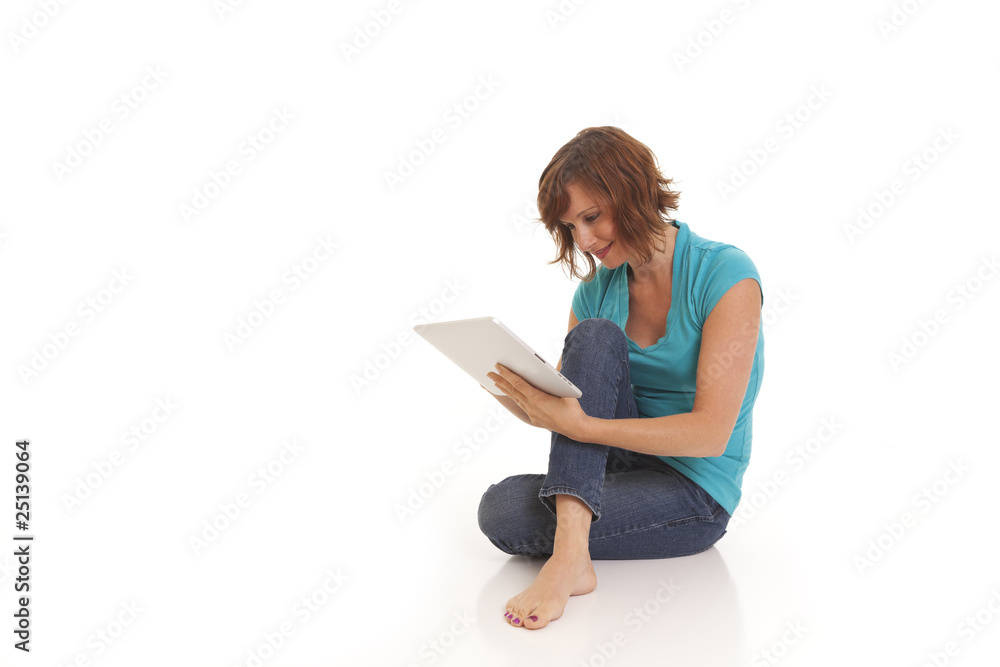 Young woman casually sitting on floor with ipad