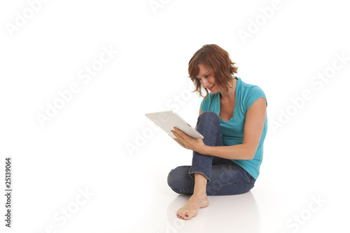 Young woman casually sitting on floor with ipad © rocketclips